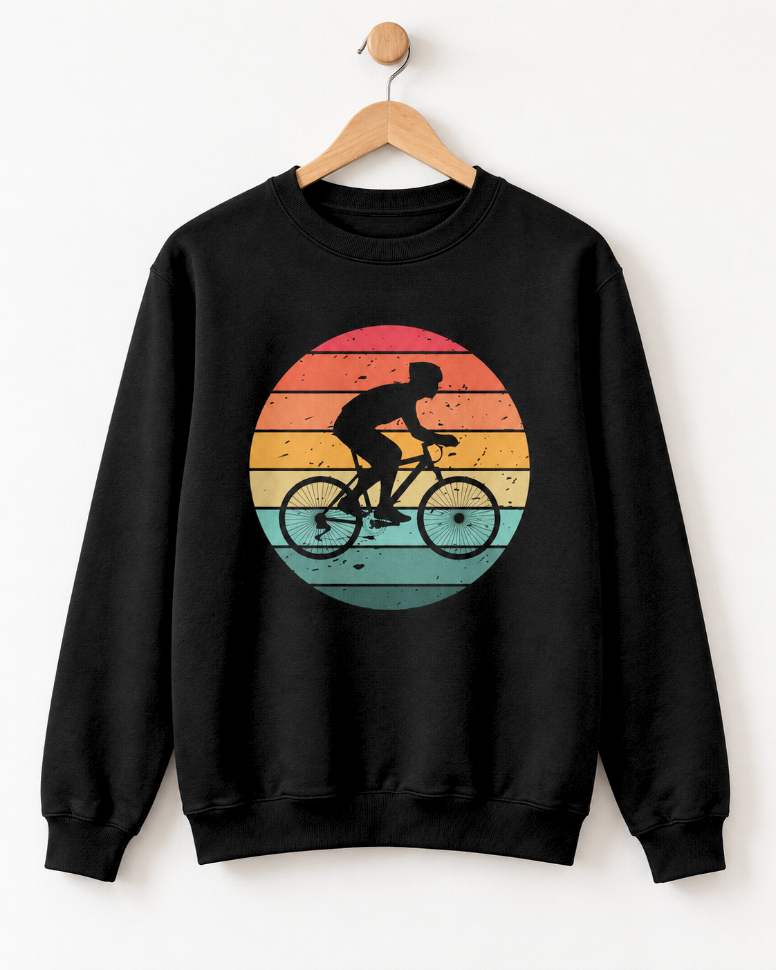 Deep black crewneck adult sweatshirt featuring a cyclist silhouette against a distressed striped sunset graphic styled on a wooden hanger.