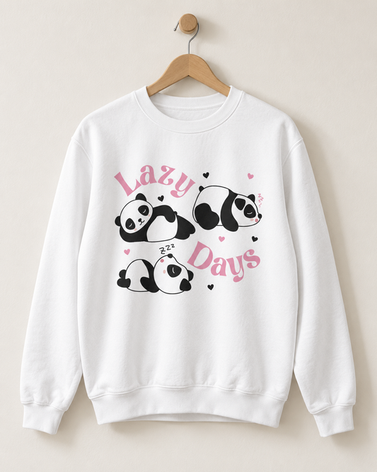 A white crewneck sweatshirt hanging on a wooden hanger against a light beige wall. The sweatshirt features a graphic print of four cute black-and-white pandas sleeping, with pink text reading 'Lazy Days' and small pink hearts.