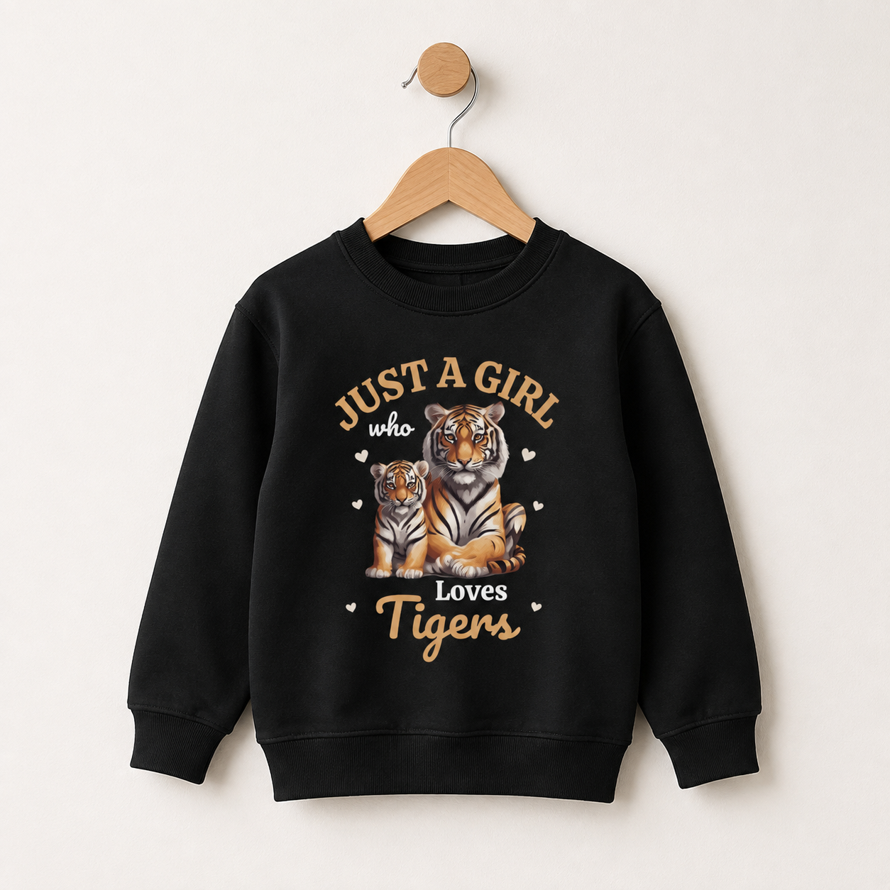 Black girls sweatshirt on a wooden hanger featuring a mother tiger and cub with small hearts and “Just a Girl Who Loves Tigers” text.