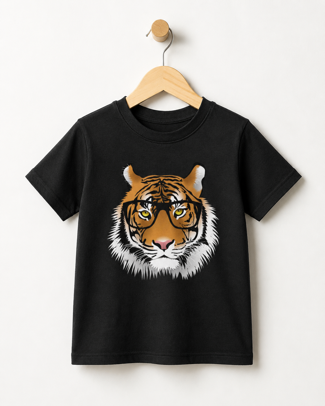 Black kids T-shirt on a wooden hanger featuring a large tiger face wearing black glasses, with orange, white and black fur details.