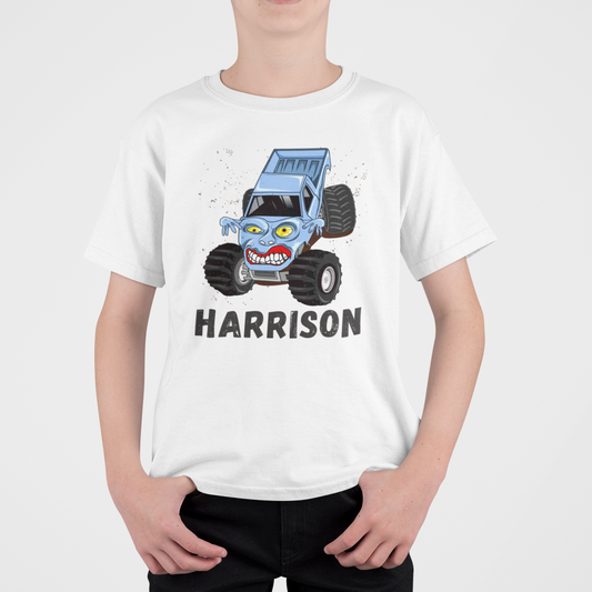 A child wearing a white T-shirt with a blue monster truck design and the name 'Harrison' printed on the front.