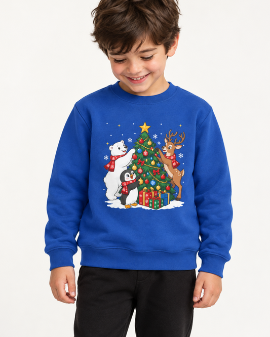 A young boy wearing a royal blue crewneck sweatshirt with a colourful Christmas graphic on the front, featuring a decorated tree, a penguin, a polar bear, and a reindeer.