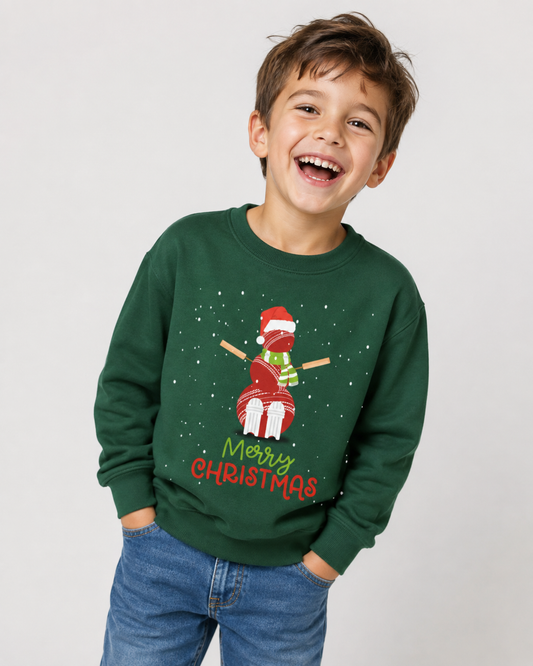 Boy wearing a dark green Christmas sweatshirt with cricket ball snowman, Santa hat, scarf and Merry Christmas print.