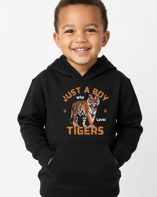 Young boy smiling wearing black “Just a Boy Who Loves Tigers” hoodie in studio setting