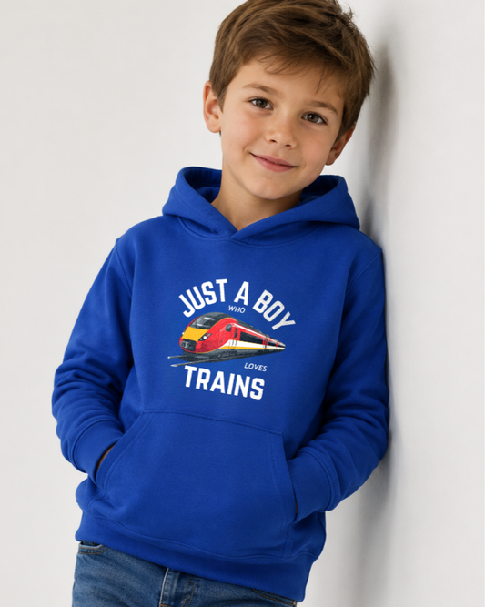 Boy wearing a royal blue Just A Boy Who Loves Trains hoodie with train graphic, hands in pocket, leaning against a white wall.