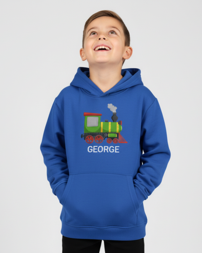 A happy boy looking up-wards models a blue pullover hoodie with a steam train design and custom name 'GEORGE' text on a studio background
