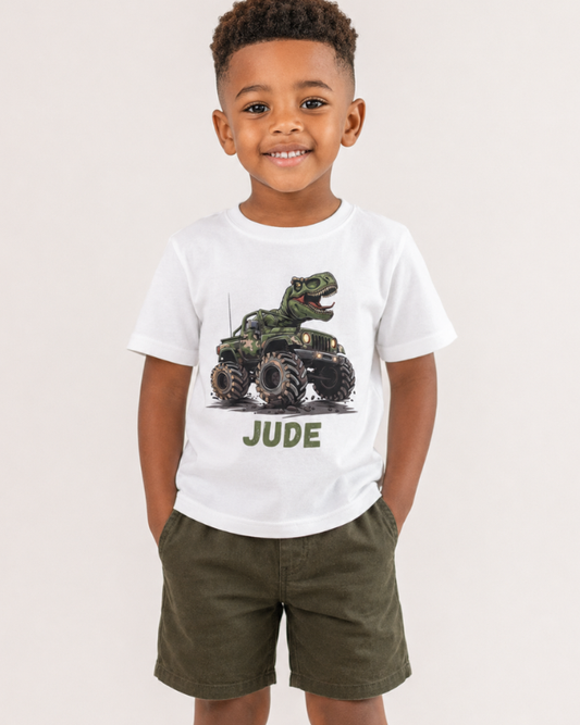 Child wearing a white t-shirt with a graphic of a camo truck and the name 'Jude' on a plain background