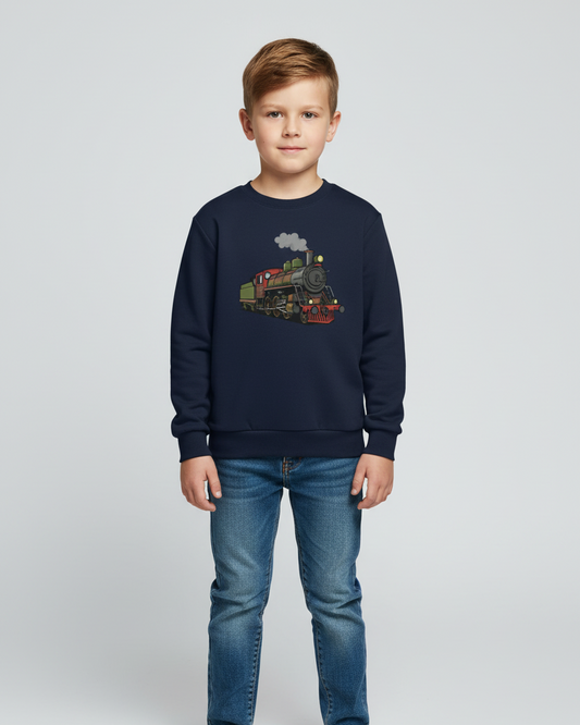 Boy model wearing a navy blue kids sweatshirt with vintage steam train graphic, paired with blue jeans, standing against a light studio background.