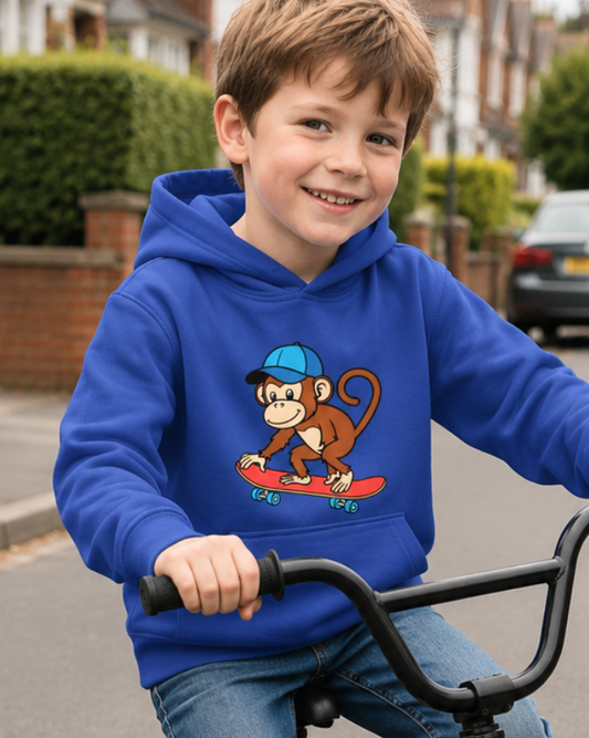 Child wearing a blue hoodie with a skateboarding monkey graphic on a bike in a residential area