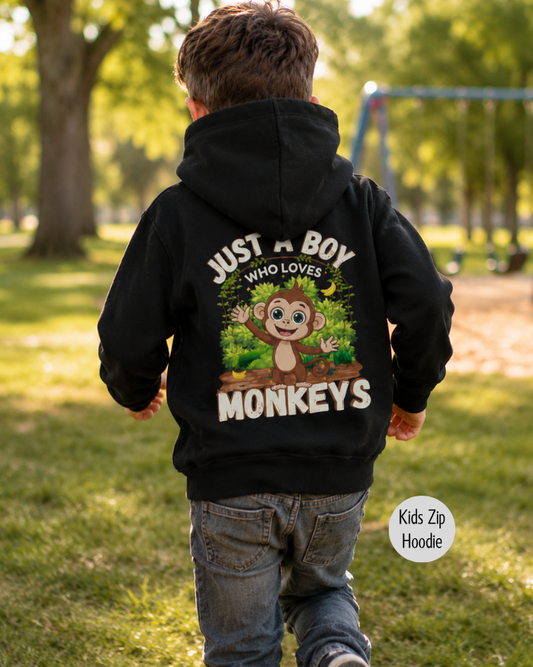 Boy running through the park wearing a kids black zip-up hoodie with a 'Just A Boy Who Loves Monkeys' back print.