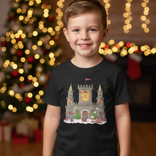 Young boy wearing a black Christmas castle and knights t-shirt in a festive holiday setting