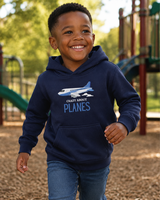 Kids 'crazy about planes' navy hoodie worn by a boy smiling outdoors in a park