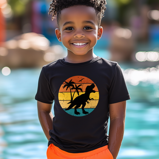 Boy wearing a black retro sunset T-Rex kids t-shirt by the pool
