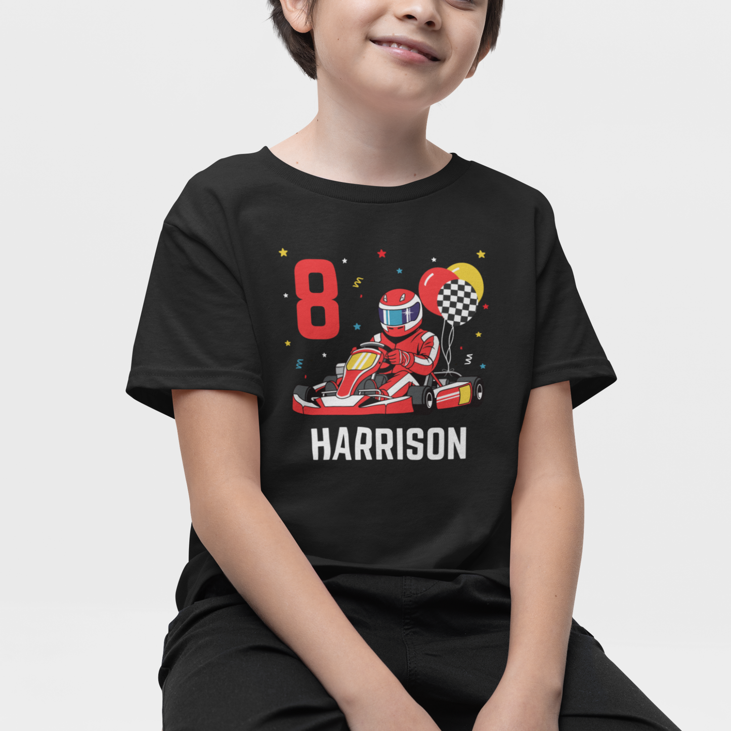 Boy wears personalised red and yellow go-kart birthday themed t-shirt with red racer, balloons, age 8 and name Harrison printed on the front.