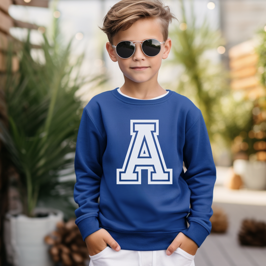 A little boy wearing a blue sweatshirt with a big white printed letter