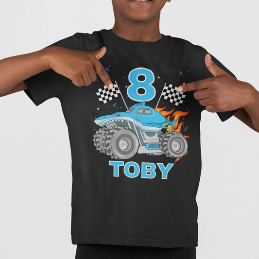 Child wearing a black t-shirt with a blue monster truck design, number 8, and name Toby on a white background.