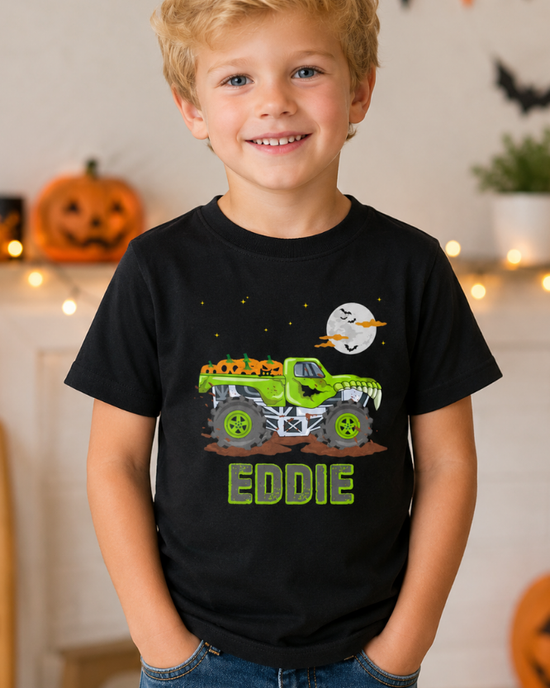 Smiling young boy wearing a personalised Halloween monster truck t-shirt with custom name in a Halloween decorated home