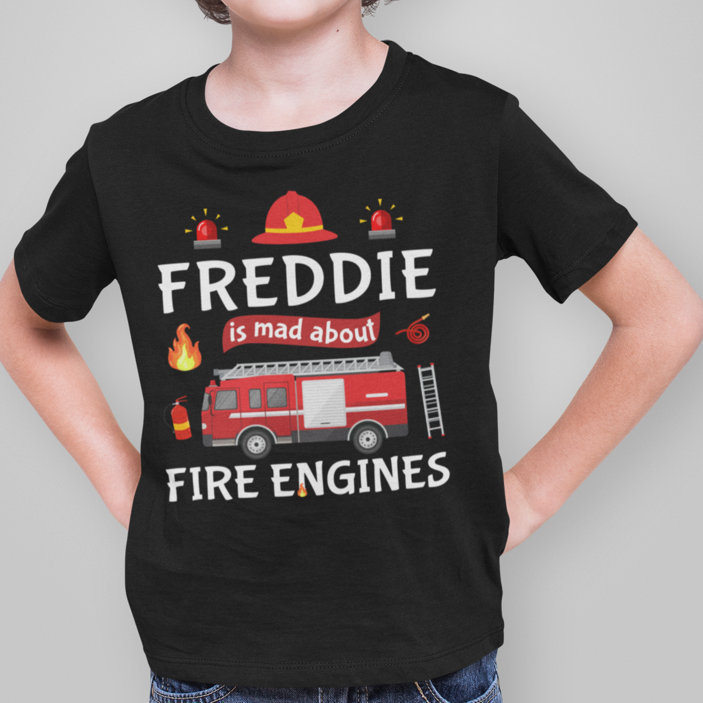 Young boy wearing a black cotton tee with red fire engine, firefighter icons and personalised text Freddie  is mad about fire engines printed on the front.
