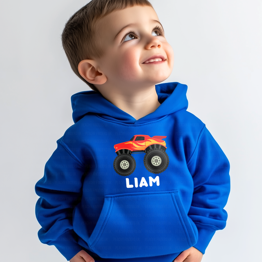 Little boy wearing a blue hoodie with a red truck graphic and 'Liam' text on a gray background