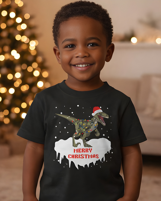 Smiling boy wearing festive dinosaur Merry Christmas t-shirt with Christmas tree lights in background