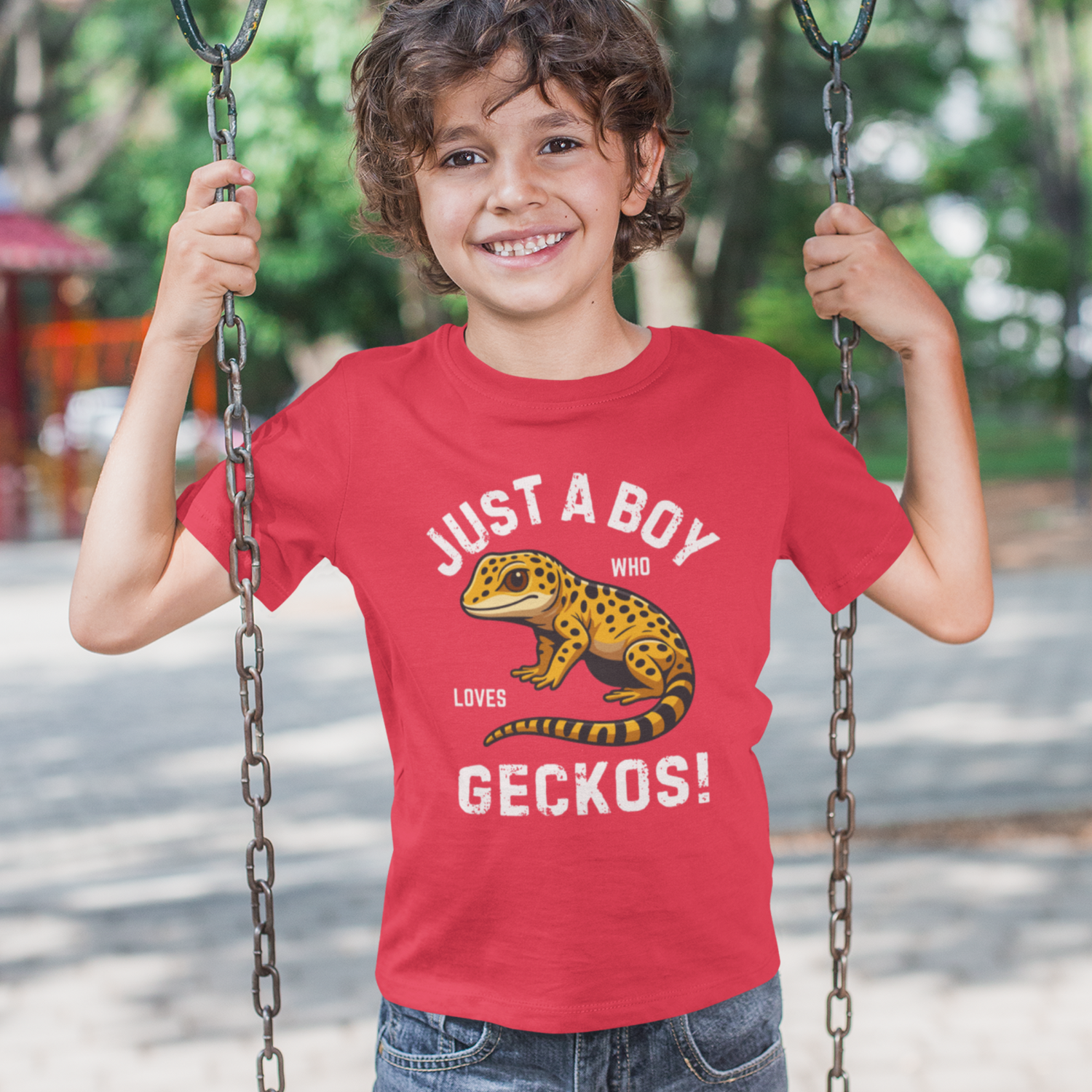 Child wearing a red t-shirt with a gecko graphic and "just a boy who loves geckos" text 