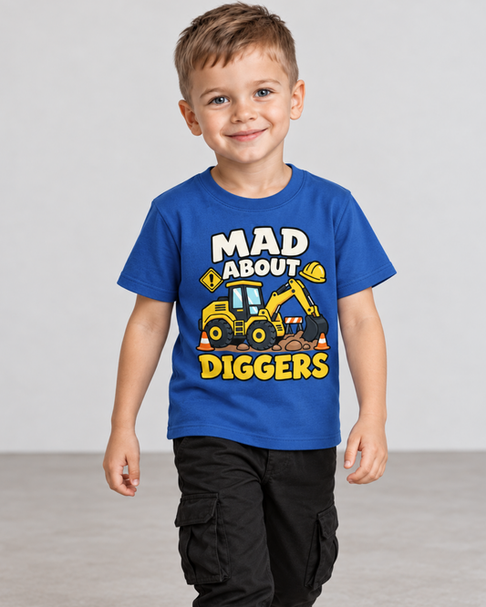 A young boy smiling and wearing a royal blue graphic t-shirt with a construction graphic and the text 'MAD ABOUT DIGGERS'.