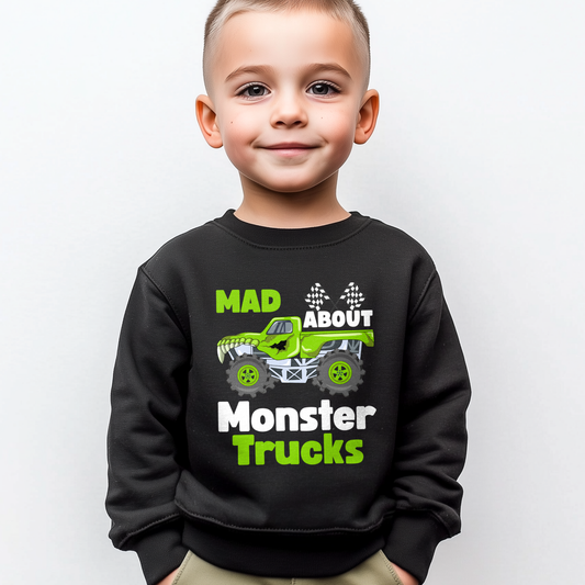 A little boy models a black sweatshirt with a green monster truck and checkered flags graphic and text "Mad about Monster Truck"