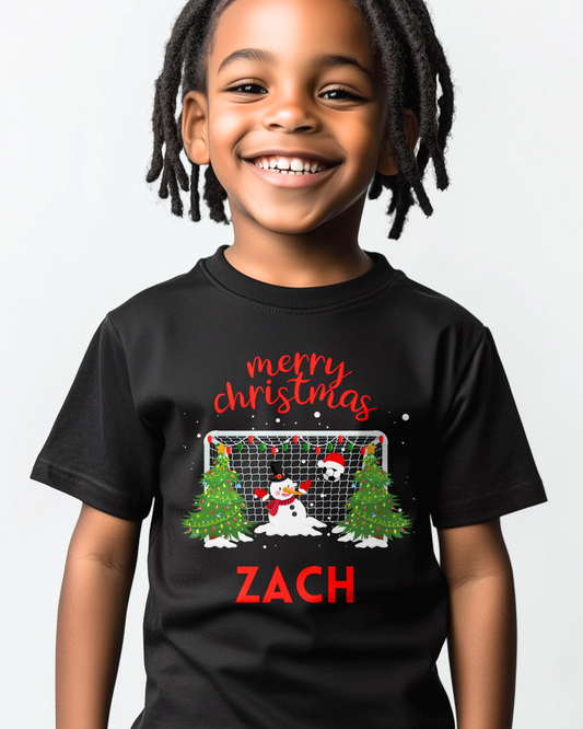 Boy wearing personalised Merry Christmas snowman goalie kids T-shirt in black with custom name