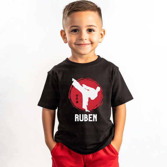 Young boy wearing a black karate t-shirt with a red and white graphic and the name 'Ruben' on a white background