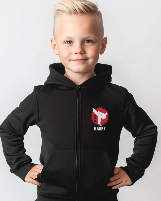 Young boy wearing a black personalised karate zip hoodie with a red martial arts emblem and the name "Harry" printed on the left chest.