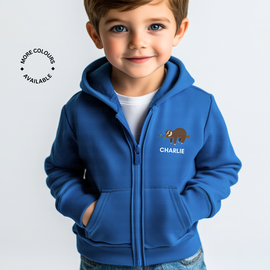 Little boy wears a royal blue zip-up hoodie featuring a cute brown sloth holding leaves with the custom name “Charlie” printed underneath.