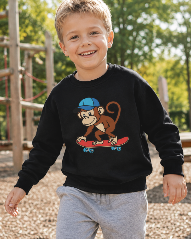 Boy wearing black skateboarding monkey sweatshirt playing outdoors in a sunny park.