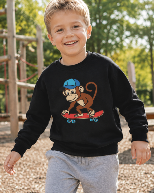Boy wearing black skateboarding monkey sweatshirt playing outdoors in a sunny park.