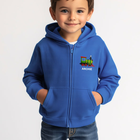 Smiling young boy wearing a royal blue zip-up hoodie with a colourful steam train design and the name "Archie" printed on the chest.