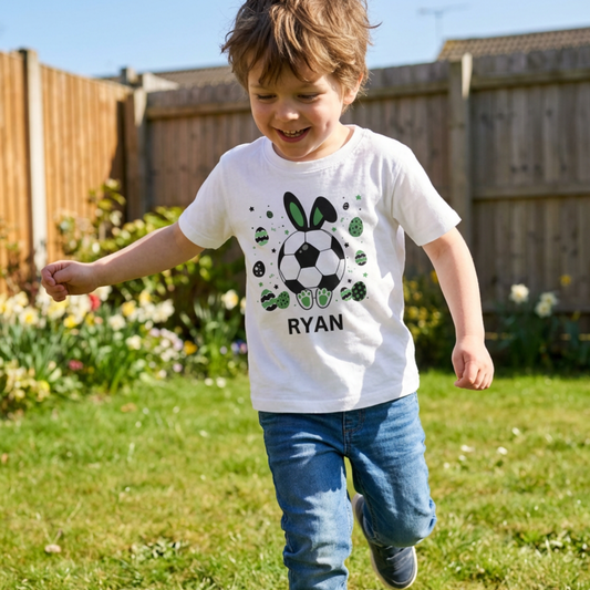 Young boy wearing a white personalised football Easter bunny T-shirt with custom name, featuring a bunny football and green Easter egg design
