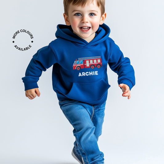 A young boy wearing a blue hooded sweatshirt with a red fire engine design and the name 'ARCHIE' printed on the front.