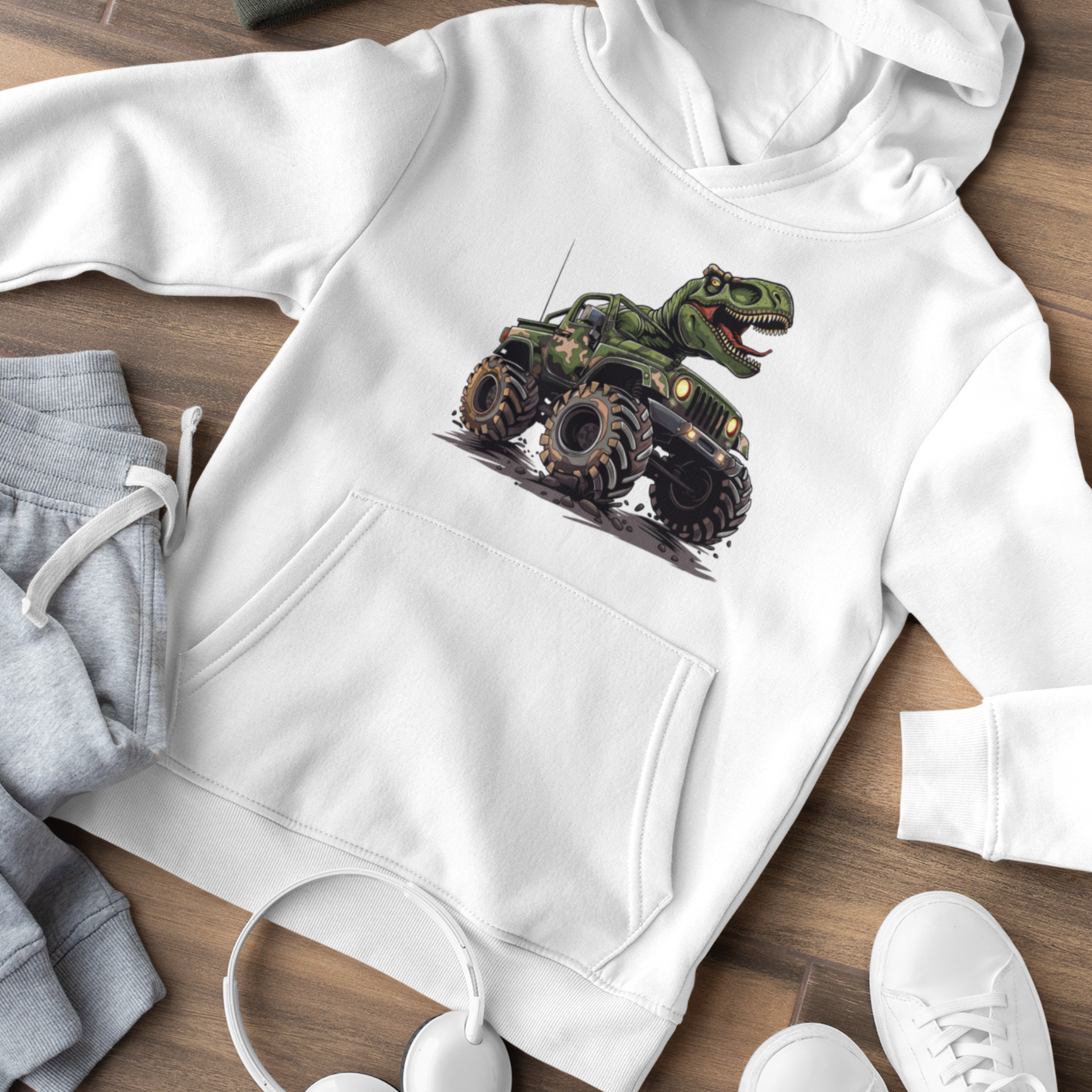 Kids white hoodie laid flat, displaying a printed design of a t-rex riding a monster truck