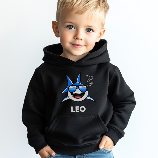 Young boy wearing personalised black pullover hoodie with cartoon shark and custom name