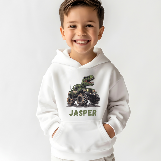 Boy wearing a white hoodie with a printed design of a T-rex driving a camouflage monster truck 