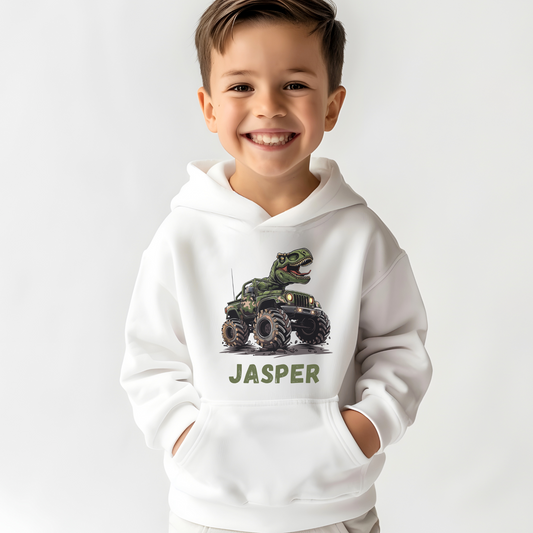 Boy wearing a white hoodie with a printed design of a T-rex driving a camouflage monster truck