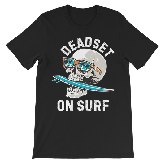 A black short-sleeve t-shirt with a graphic of a skull wearing sunglasses and holding a blue surfboard, with the text 'DEADSET ON SURF' printed in white.
