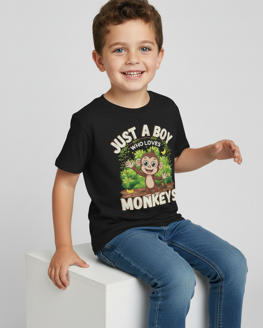 Kids black monkey t-shirt “Just A Boy Who Loves Monkeys” worn by smiling young boy sitting on studio cube