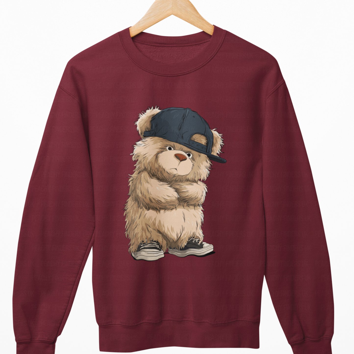 Maroon sweatshirt with a teddy bear wearing a cap on a white background