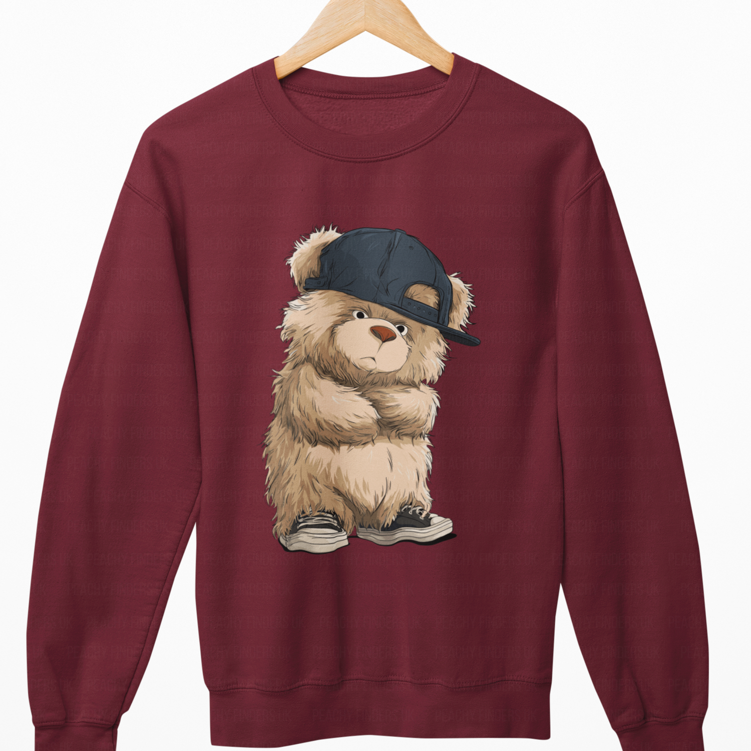 Maroon sweatshirt with a teddy bear wearing a cap on a white background