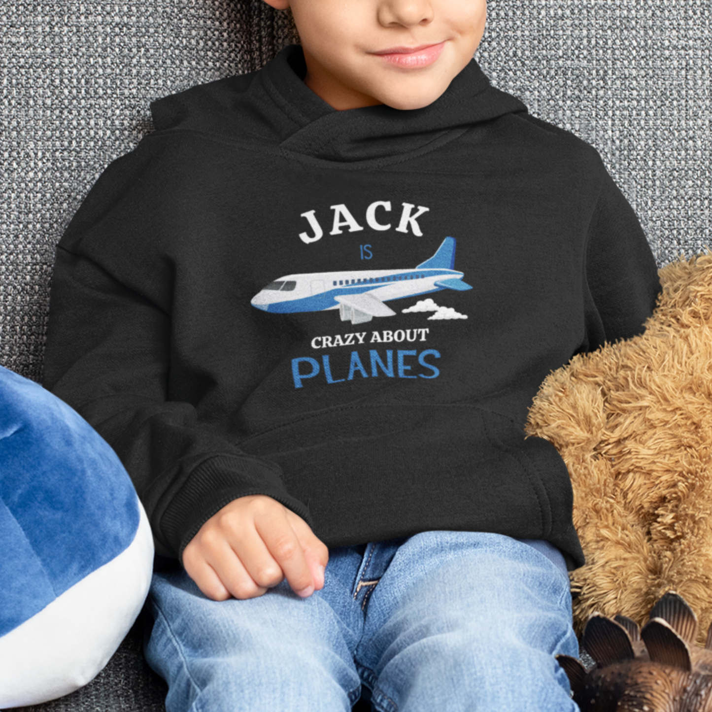 a boy wearing black hoddie with a printed plane design and the wording jack is crazy about planes