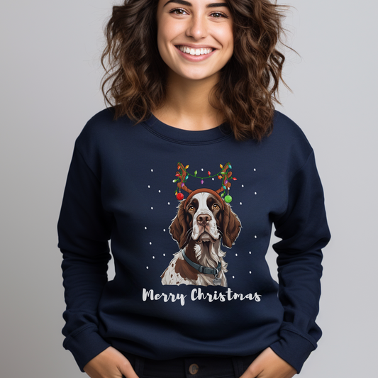 Woman wearing a navy Christmas sweatshirt featuring a festive Springer Spaniel with bauble antlers and snowflakes