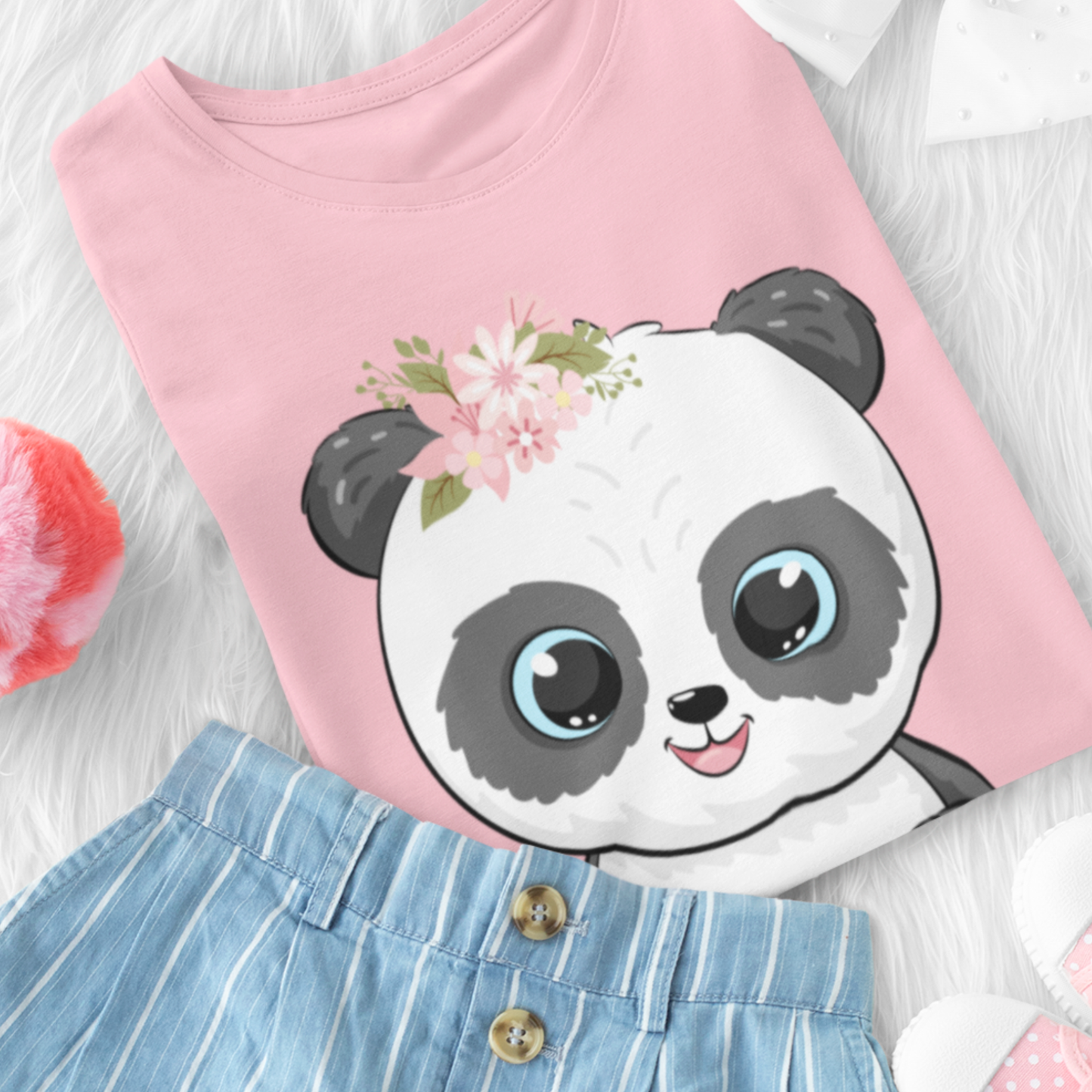 Girls pink organic cotton t-shirt featuring a cute panda illustration with big blue eyes and a floral crown, styled with denim shorts