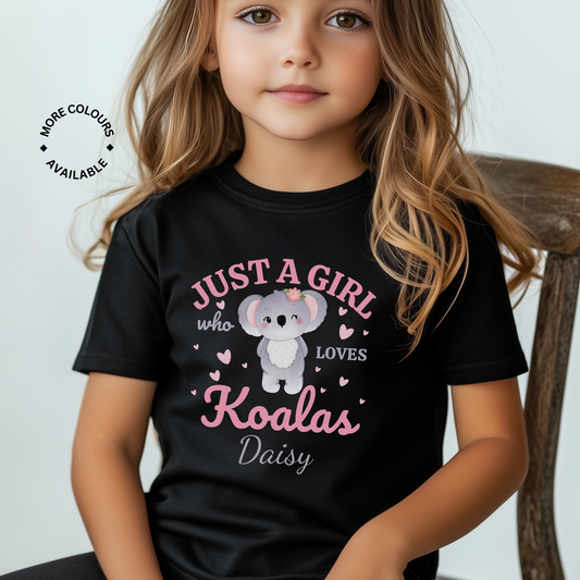 Young girl sitting on a chair wearing a black T-shirt with a pink and white design that reads “Just a Girl Who Loves Koalas” and the personalised name “Daisy” below.