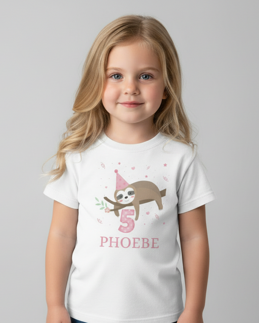 Girl modelling white personalised 5th birthday sloth t-shirt with pink number 5 and name PHOEBE in studio.