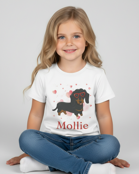 Child wearing a white t-shirt with a dachshund graphic and 'Mollie' text on a plain background